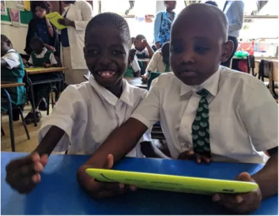Derrick and Collins in their classroom interacting with the digital accessible textbook