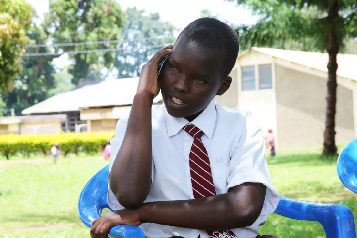 Jane Drichiru, estudiante de 13 años con baja visión del primer año superior de la escuela secundaria de Gulu habla con su antiguo maestro de la escuela primaria Kamurasi.